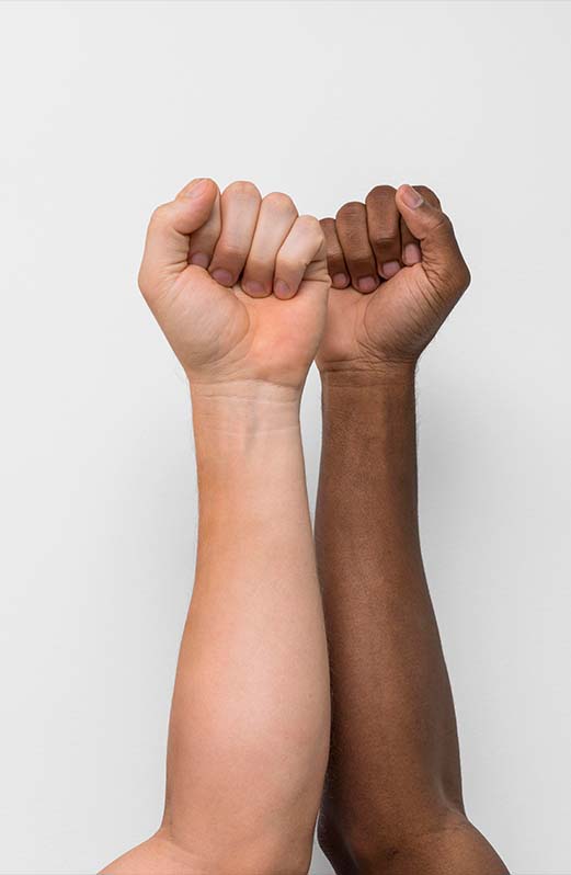 Hands of many different skin tones reaching in towards one another